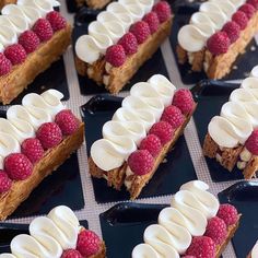 several desserts with raspberries and whipped cream on them are arranged in rows