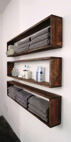 two wooden shelves holding towels and other bathroom items