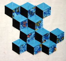 an abstract piece of art made out of blue and black squares with butterflies on them