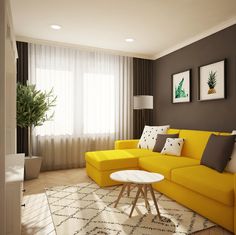 a living room with yellow couches and white table in front of the window, next to a potted plant