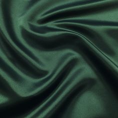 a close up view of a green satin fabric with very soft folds and smooth lines