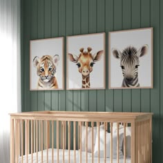 a baby's room with three framed pictures on the wall and a crib