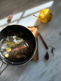 a pot with some food inside of it next to an apple and spices on the table