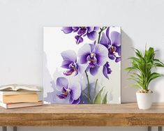 a wooden table topped with books and a vase filled with purple flowers