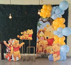 winnie the pooh birthday party decorations with balloons and wall art in front of it