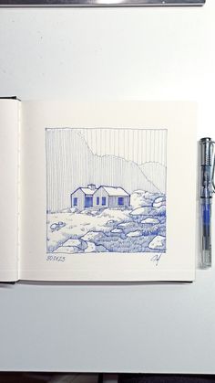 an open book with a drawing of a house in the background and a pen next to it