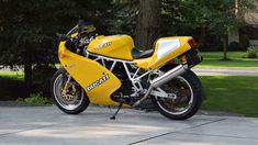 a yellow motorcycle parked in front of a tree