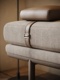 a pair of pillows sitting on top of each other next to a metal stand with a cushion