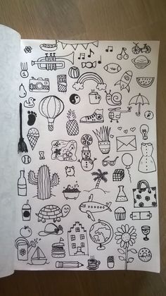 an open notebook with doodles on it and various things drawn in the book's pages