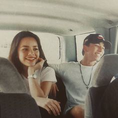 a man and woman sitting in the back of a car