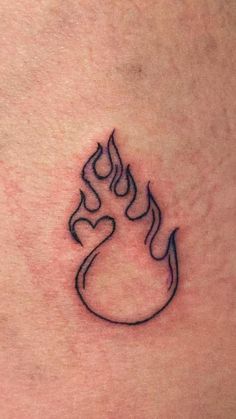 a small tattoo on the back of a woman's stomach that has a flame coming out of it