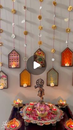 a table topped with lots of candles and plates filled with different types of decorations hanging from the ceiling