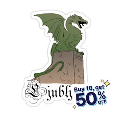 a green dragon sitting on top of a pile of paper next to a sale sign