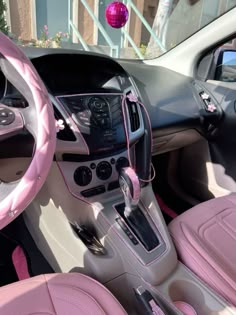 the interior of a pink and black car