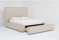 an upholstered bed with two pillows on it