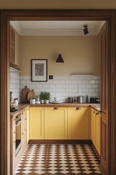 a kitchen with yellow cabinets and black and white checkerboard flooring on the walls