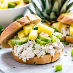 a chicken salad sandwich with pineapples and celery on the side, ready to be eaten