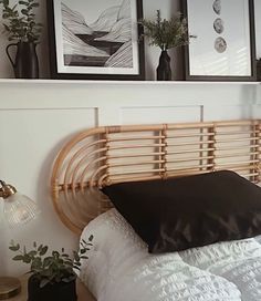 a bed with black pillows and pictures on the wall