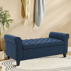 a blue bench sitting on top of a rug in a living room next to a potted plant