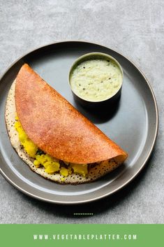 there is a plate with a sandwich on it and a bowl of soup in the background