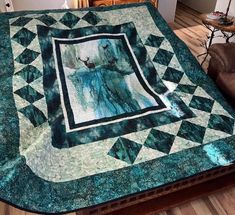 a green and white quilt on top of a wooden table next to a brown chair