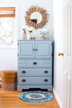 a blue dresser in the corner of a room with a round rug on the floor