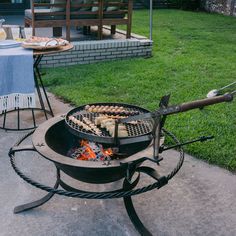 an outdoor bbq grill with food cooking on it in the middle of a yard