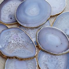 some very pretty blue and white plates on top of a wooden table with gold rims