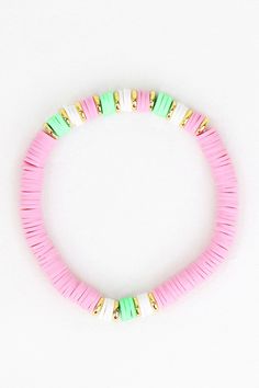 a pink and green beaded bracelet on a white surface with gold beads in the middle