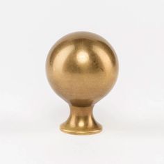 a gold colored metal ball on a white background