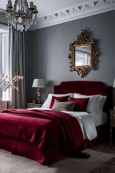 a bedroom with a red bed, chandelier and two lamps on either side of the bed