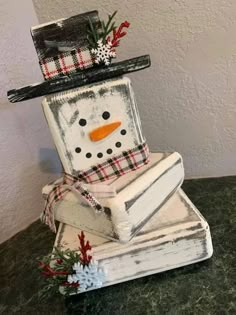 a snowman is sitting on top of two boxes that are stacked up and decorated