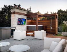 an outdoor living area with white furniture and a flat screen tv mounted on the wall