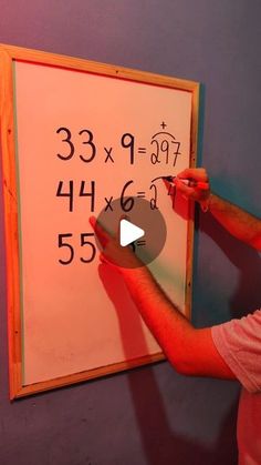 a man is writing on a whiteboard with numbers