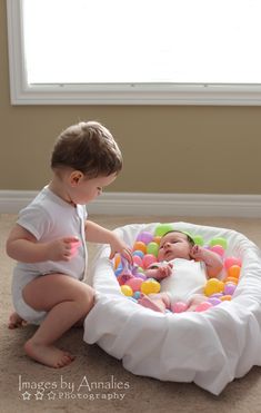 a baby playing with an infant in a play mat