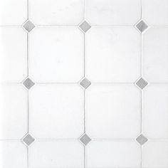 a white tiled wall with small squares on it