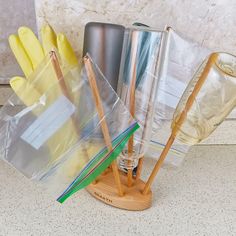 an assortment of kitchen utensils and cleaning supplies in plastic bags on a counter