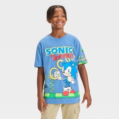 Let your kid show off their favorite character with this Sonic the Hedgehog Wrap Short-Sleeve Graphic T-Shirt. Made from cotton-polyester blend material in a blue color, this T-shirt falls to the waist and features a Sonic graphic and the game title "Sonic the Hedgehog." Tailored in a standard fit, this short-sleeve T-shirt has a crew neckline for a classic look. Plus, the pullover style makes it easy to wear for birthday parties, casual outings and more. Wrap Shorts, Game Title, Kids Clothes Boys, Target Clothes, Kids Shows, Top Graphic Tees, 6th Birthday, The Hedgehog, Jersey Fabric