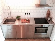 a kitchen with stainless steel appliances and white tiled walls