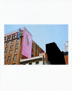 an old building with a pink advertisement on it's side