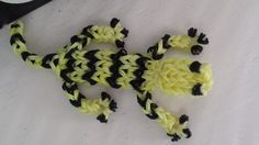 a small yellow and black gecko sitting on top of a white table next to scissors