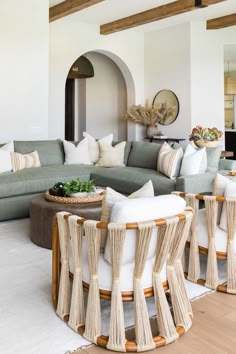 a living room filled with lots of furniture and decor on top of a hard wood floor