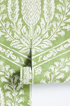 a green and white wallpaper with an intricate design on it's back side