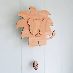 a wooden lion clock hanging on the wall