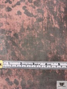 a ruler is on top of a brown and black fabric with spots in the middle