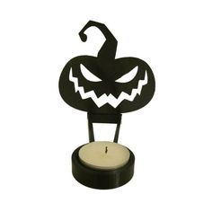 a black candle holder with a jack - o'- lantern face on the front