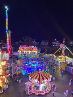 an aerial view of the fairground at night with rides and carousels lit up