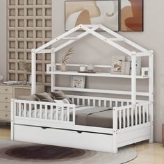 a child's bed with a white wooden frame and mattress underneath it, in a bedroom