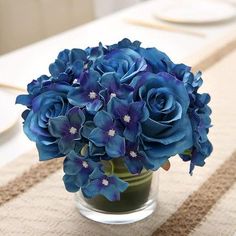 there is a vase with blue flowers on the table