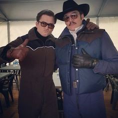 two men in cowboy hats and jackets posing for the camera